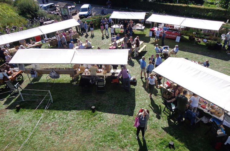 Sfeervolle opname van het Alphen Cultuurnacht stadsfestival met bezoekers, muziekuitvoeringen en eetkraampjes in het centrum van Alphen aan den Rijn.