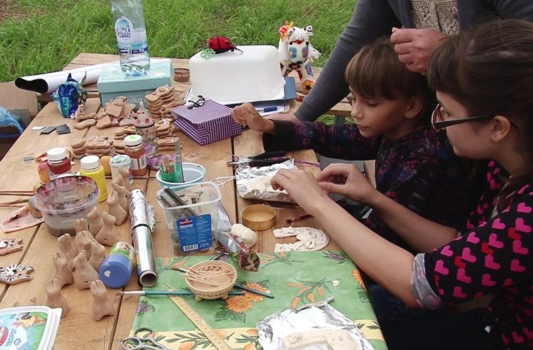 Bezoeker onderzoekt een prehistorische vuursteenartefact tijdens demonstratie in het openluchtmuseum Archeon
